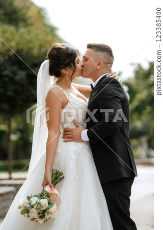the groom in a brown suit and the bride in a white dress 123385490