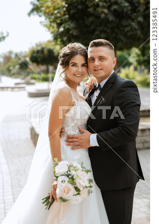 the groom in a brown suit and the bride in a white dress 123385491