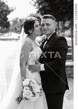 the groom in a brown suit and the bride in a white dress the groom in a brown suit and the bride in a white dress 123385492