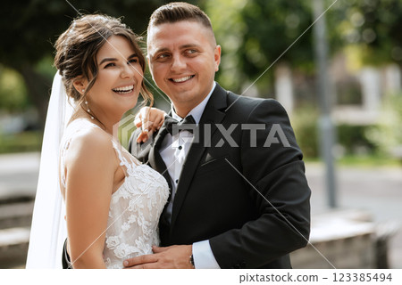 the groom in a brown suit and the bride in a white dress 123385494