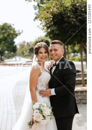 the groom in a brown suit and the bride in a white dress the groom in a brown suit and the bride in a white dress 123385495