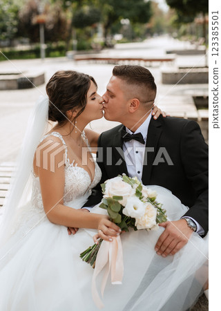the groom in a brown suit and the bride in a white dress the groom in a brown suit and the bride in a white dress 123385501