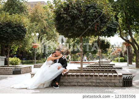 the groom in a brown suit and the bride in a white dress the groom in a brown suit and the bride in a white dress 123385506