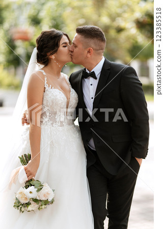 the groom in a brown suit and the bride in a white dress the groom in a brown suit and the bride in a white dress 123385518