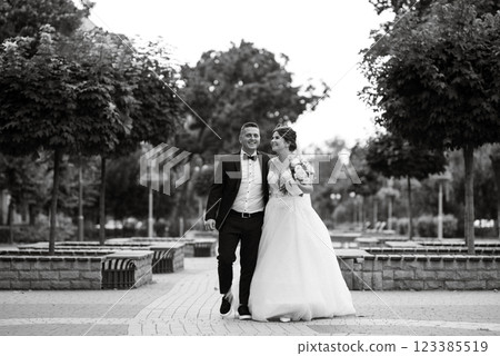 the groom in a brown suit and the bride in a white dress 123385519