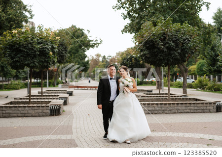the groom in a brown suit and the bride in a white dress the groom in a brown suit and the bride in a white dress 123385520
