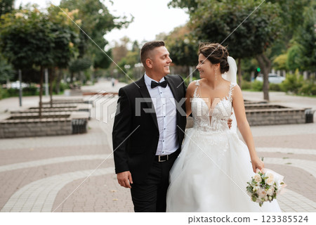 the groom in a brown suit and the bride in a white dress the groom in a brown suit and the bride in a white dress 123385524