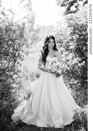 young girl bride in a white dress in a spring forest in lilac bushes 123385676