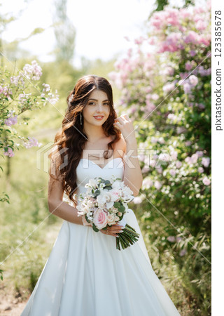 young girl bride in a white dress in a spring forest in lilac bushes young girl bride in a white dress in a spring forest in lilac bushes 123385678