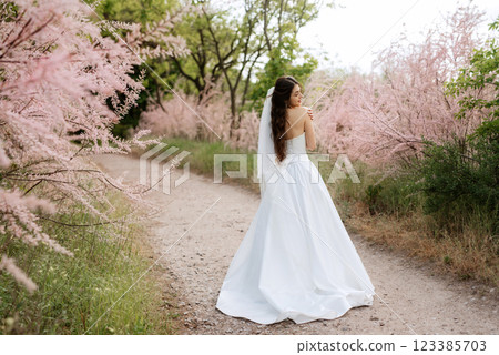 a young girl bride in a white dress is spinning on a path a young girl bride in a white dress is spinning on a path 123385703