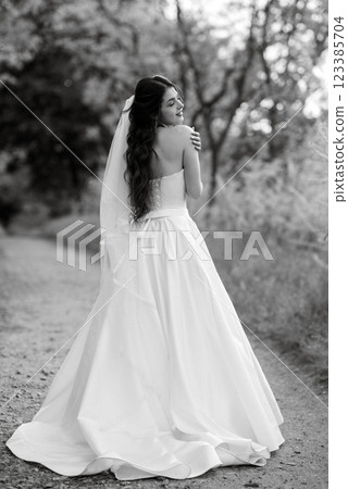 a young girl bride in a white dress is spinning on a path a young girl bride in a white dress is spinning on a path 123385704
