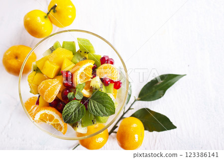 Sweet mandarins and green leaves on light background 123386141