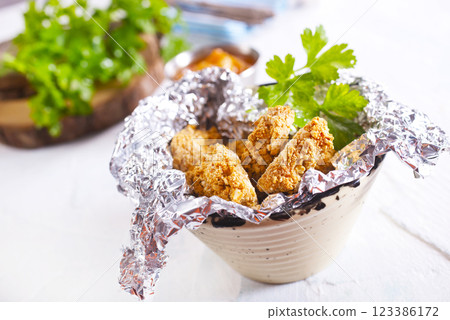 Delicious fresh crispy chicken nuggets on light background. Delicious fresh crispy chicken nuggets on light background. 123386172