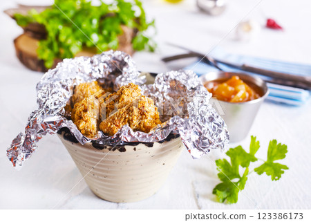Delicious fresh crispy chicken nuggets on light background. Delicious fresh crispy chicken nuggets on light background. 123386173