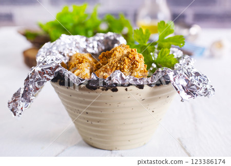 Delicious fresh crispy chicken nuggets on light background. Delicious fresh crispy chicken nuggets on light background. 123386174