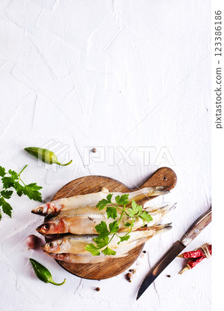Fresh fish and spice on white table Fresh fish and spice on white table 123386186