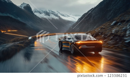 Sleek electric car driving on winding mountain road at sunset. Automotive battery 123386231