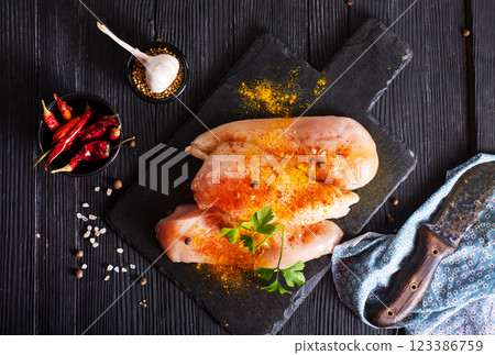 Raw fresh chicken fillet on black stone board Raw fresh chicken fillet on black stone board 123386759