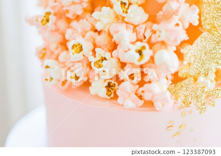 Close-up of pink cake with popcorn and gold 123387093