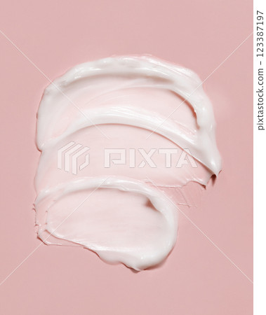 Cosmetic cream smear on a light pink top view. Skincare product texture swipe smudge Cosmetic cream smear on a light pink top view. Skincare product texture swipe smudge 123387197