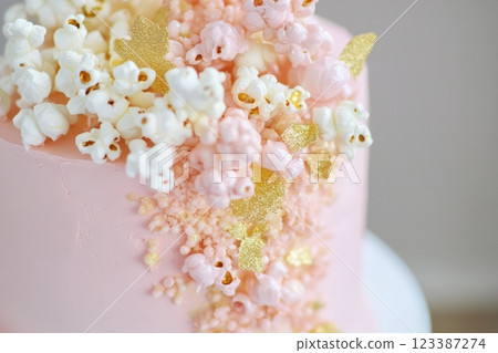 Close-up of pink cake with popcorn and gold 123387274