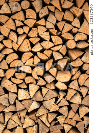 Stacked split hardwood firewood arranged in a row for drying 123387540