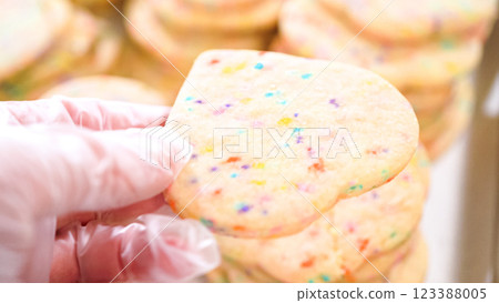 The sugar cookies, filled with sprinkles mixed into the dough, are carefully arranged with meticulous precision into a rustic brown paper box. The sugar cookies, filled with sprinkles mixed into the dough, are carefully arranged with meticulous precision into a rustic brown paper box. 123388005