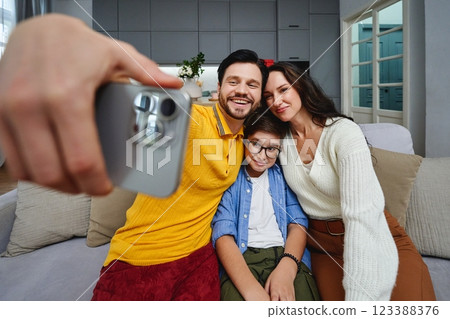 Family taking a joyful selfie together in a cozy living room setting 123388376