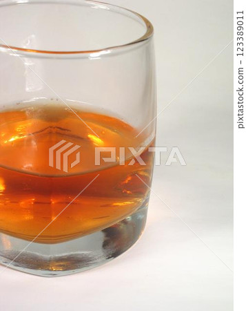 Glass of whiskey on white background Glass of whiskey on white background 123389011
