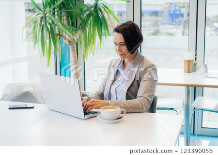 Portrait of concentrated 50's confident mature businesswoman, middle-aged experienced senior female professional working on laptop in open space office. Female entrepreneur working remotely Portrait of concentrated 50's confident mature businesswoman, middle-aged experienced senior female professional working on laptop in open space office. Female entrepreneur working remotely 123390056