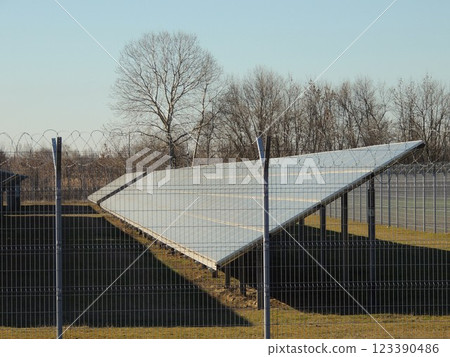 large solar panel behind wire fence as part of processing plant, industrial power generation with solar panels, battery at solar power plant in countryside 123390486