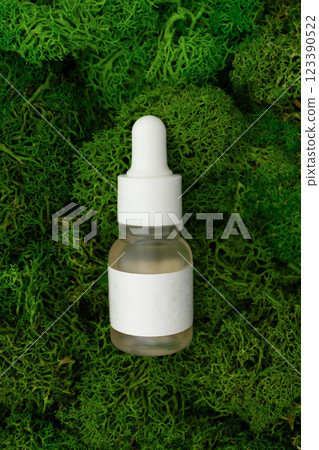Organic skincare facial serum glass bottles with pipette on green moss background Organic skincare facial serum glass bottles with pipette on green moss background 123390522
