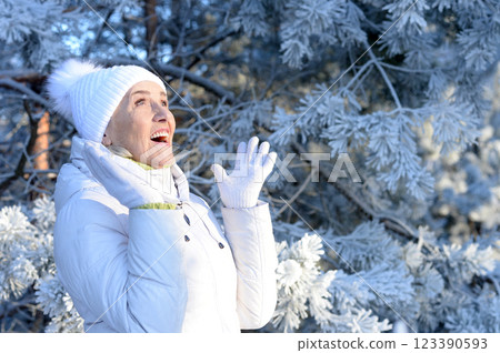 Beautiful elderly woman posing in a snowy winter park 123390593