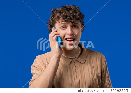 Smiling positive man talking by phone, smiling. Mature guy on blue background. 123392205