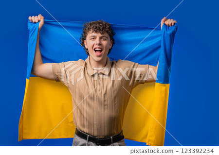 Happy young man with national Ukrainian flag. Ukraine, patriot, victory, fan Happy young man with national Ukrainian flag. Ukraine, patriot, victory, fan 123392234