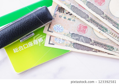 A bankbook, a seal, and a 10,000 yen note on a table 123392581