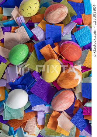 Colorful Easter eggs on a vibrant crepe paper decorative background, top view Colorful Easter eggs on a vibrant crepe paper decorative background, top view 123392904