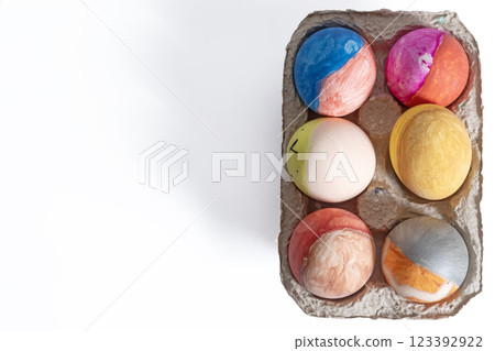 Colorful decorated Easter eggs in a cardboard box on a white background Colorful decorated Easter eggs in a cardboard box on a white background 123392922