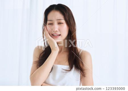 一名婦女因牙痛摀住臉頰 123393000