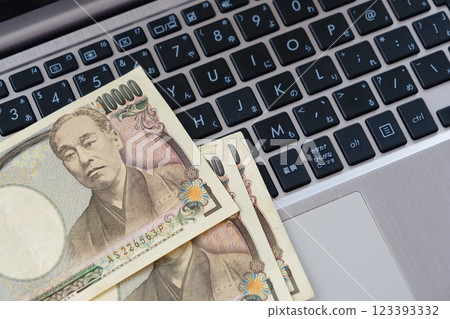 An image of freely developing business online using the internet with a computer keyboard and a 10,000 yen note An image of freely developing business online using the internet with a computer keyboard and a 10,000 yen note 123393332
