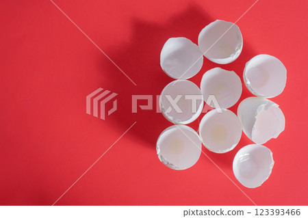 Broken eggshells arranged on a vibrant red background. Top view Broken eggshells arranged on a vibrant red background. Top view 123393466