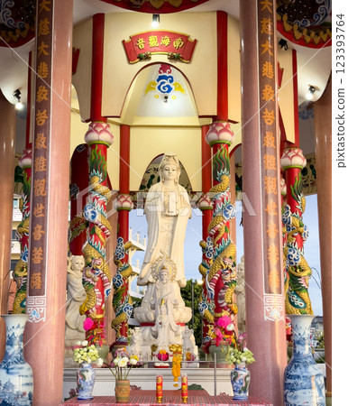 Large statue of Guanyin in colorful temple with dragon columns during sunny afternoon. Sriracha, Thailand. 123393764