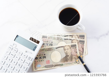 一張印有福澤莔吉肖像的 10,000 日元紙幣、一台計算器和一杯現煮咖啡 123393766