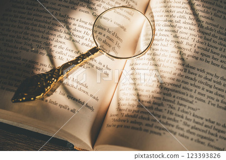 A book with sunlight coming through a window, a magnifying glass and dried flowers A book with sunlight coming through a window, a magnifying glass and dried flowers 123393826