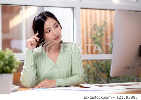 Young asian business woman working with desktop computer while thoughtful for planning financial. Young asian business woman working with desktop computer while thoughtful for planning financial. 123393983