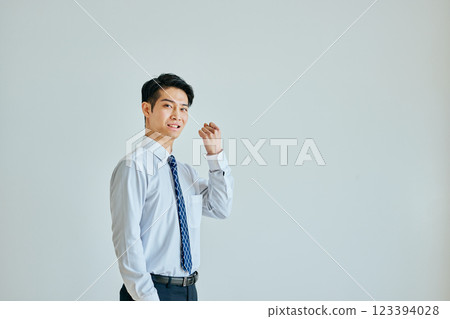 A young man in a dress shirt making a fist pump 123394028