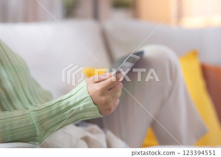 Young asian woman sitting on sofa using tablet computer shopping online with credit card. Young asian woman sitting on sofa using tablet computer shopping online with credit card. 123394551