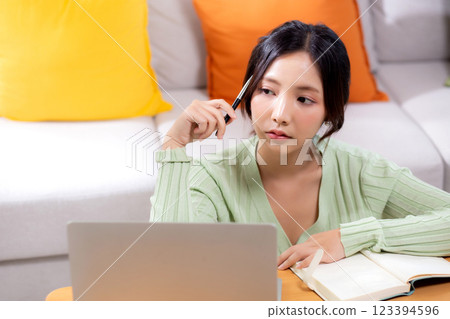 Young asian woman planning and strategy about finance and investment or tax while thoughtful. 123394596