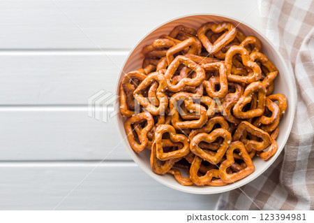 Heart shaped pretzel in bowl on white table. Top view. Heart shaped pretzel in bowl on white table. Top view. 123394981