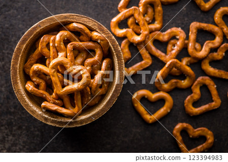 Heart shaped pretzel in bowl on black table. Top view. Heart shaped pretzel in bowl on black table. Top view. 123394983